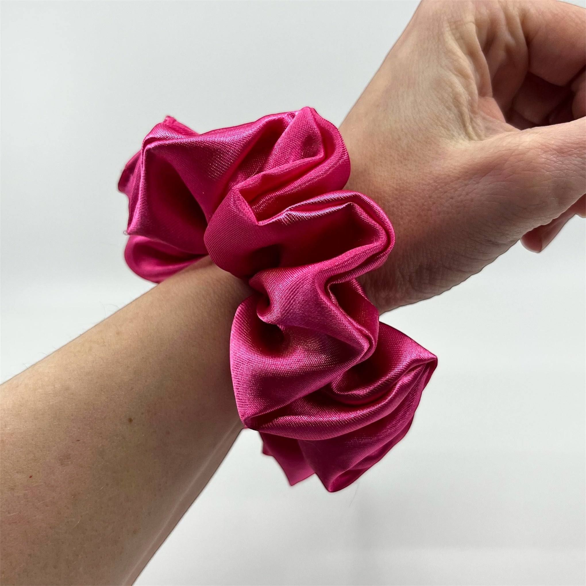 rosa classic satin scrunchie på handleden