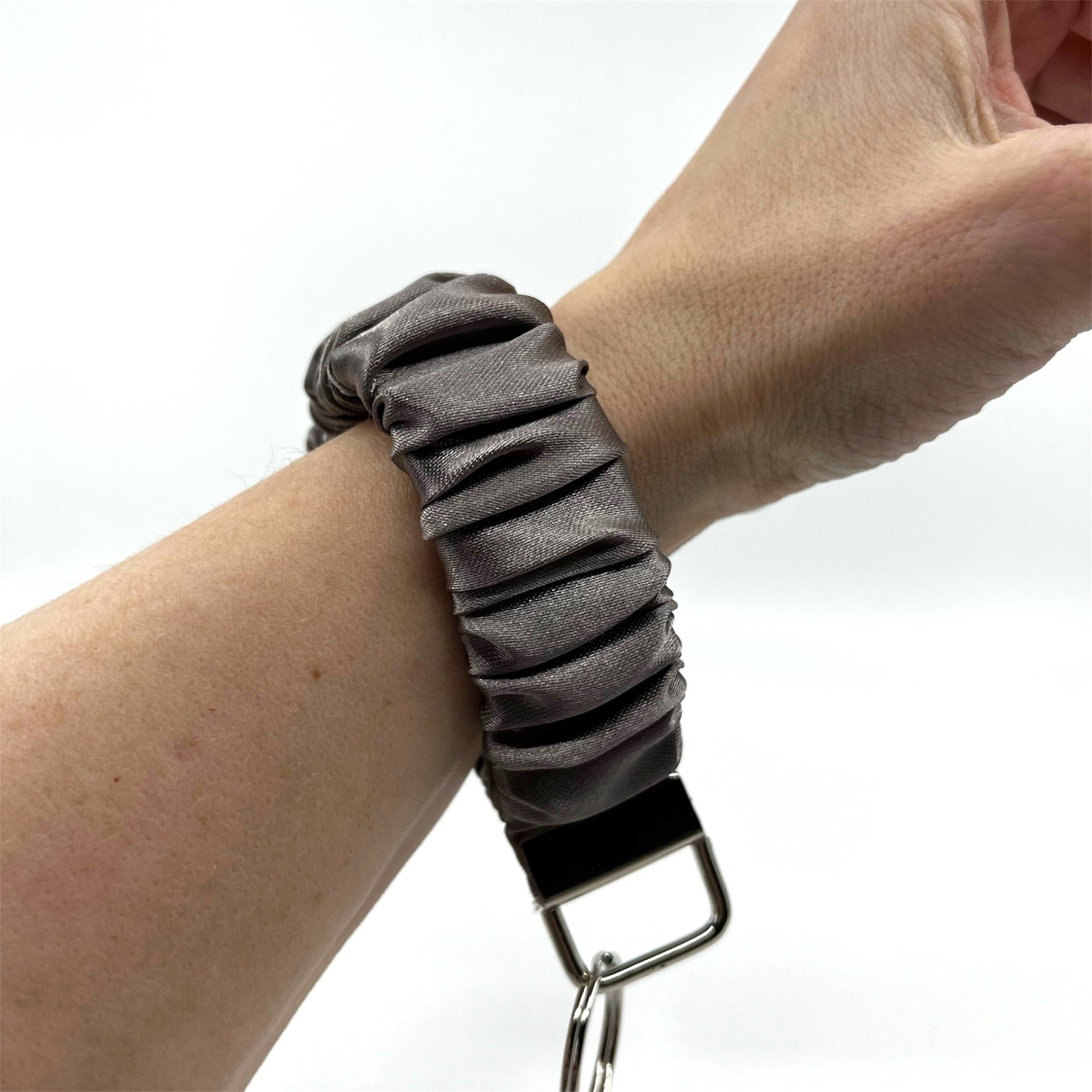 ljus taupe scrunchie nyckelring på handleden