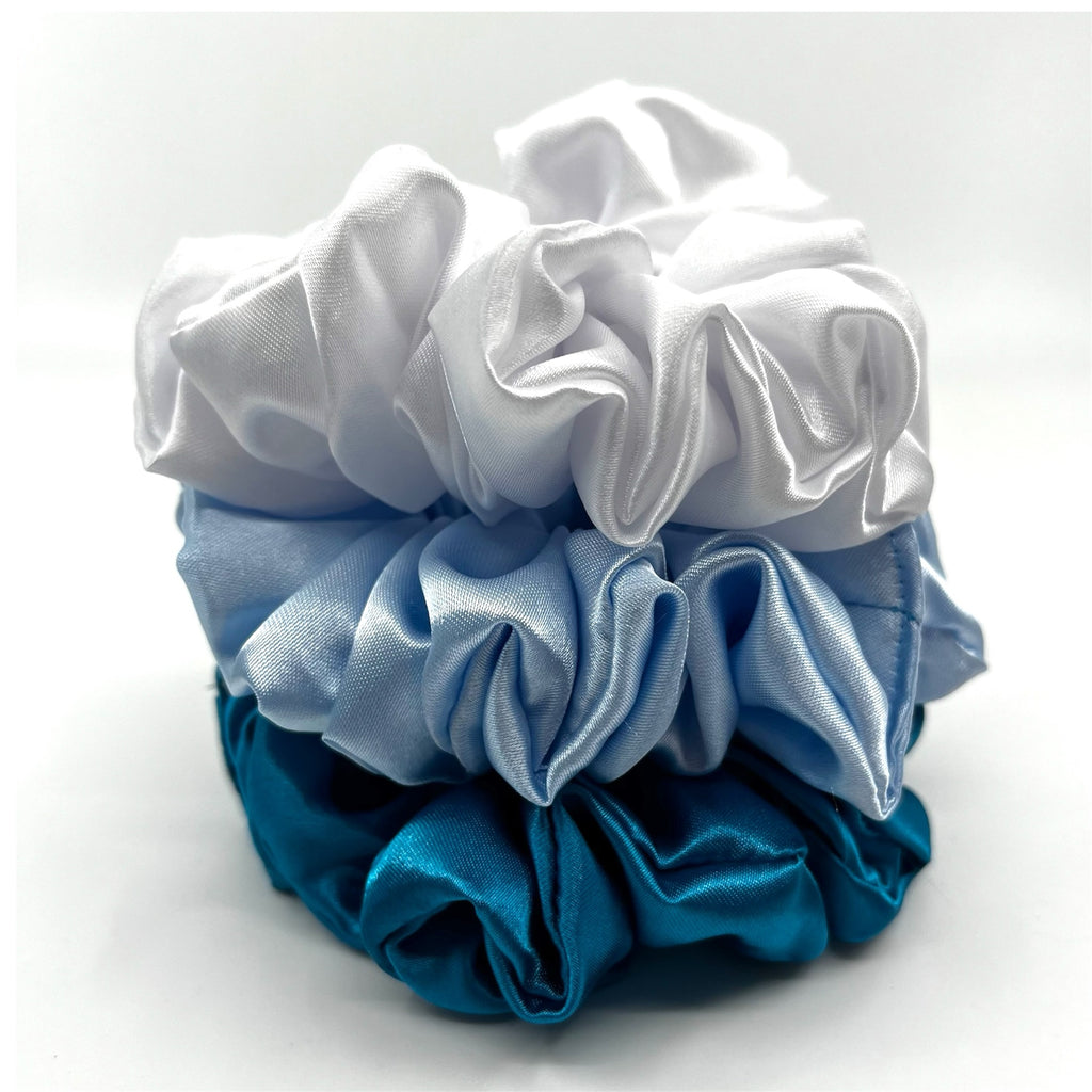 mörk turkos classic scrunchie liggandes på torn