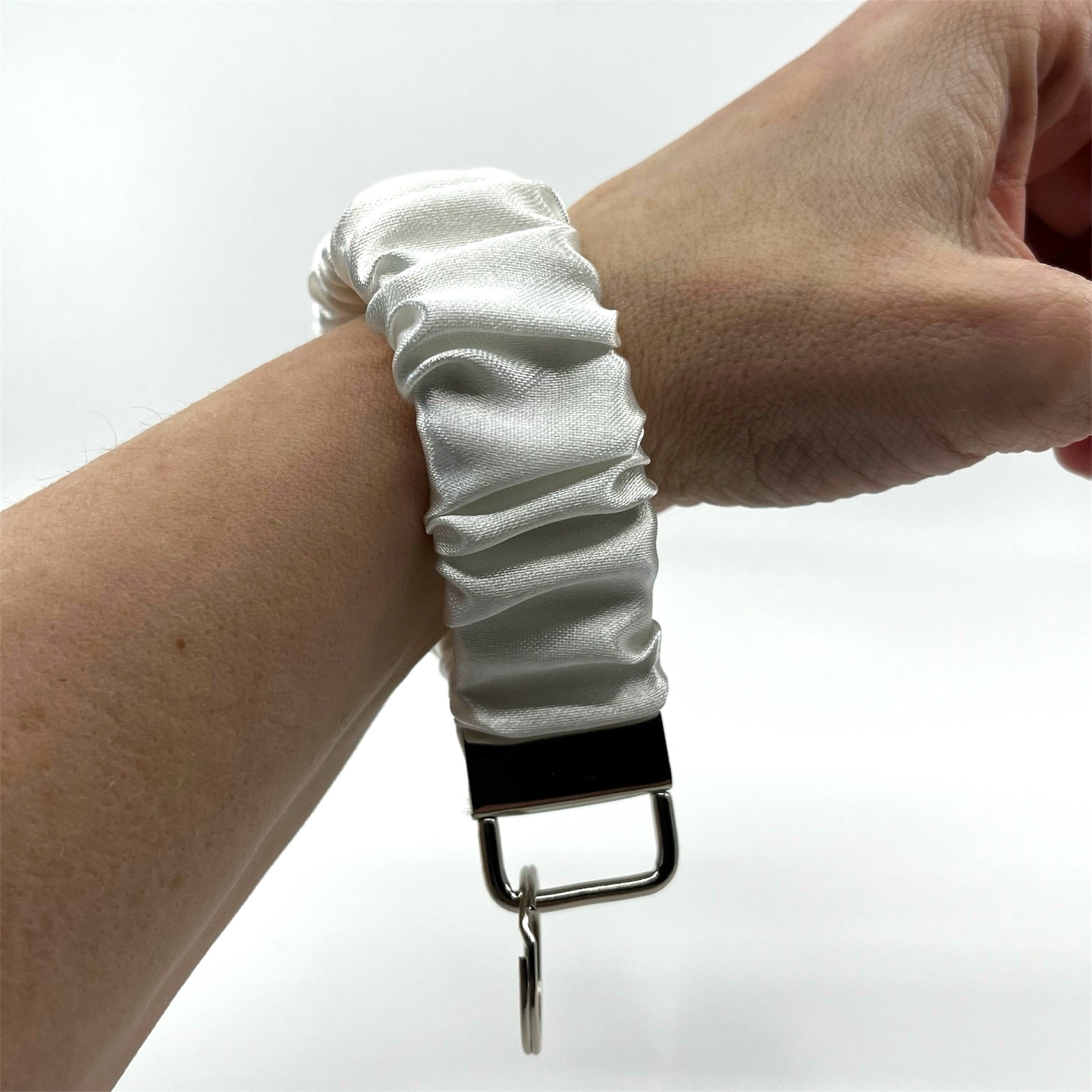 vit scrunchie nyckelring på handleden