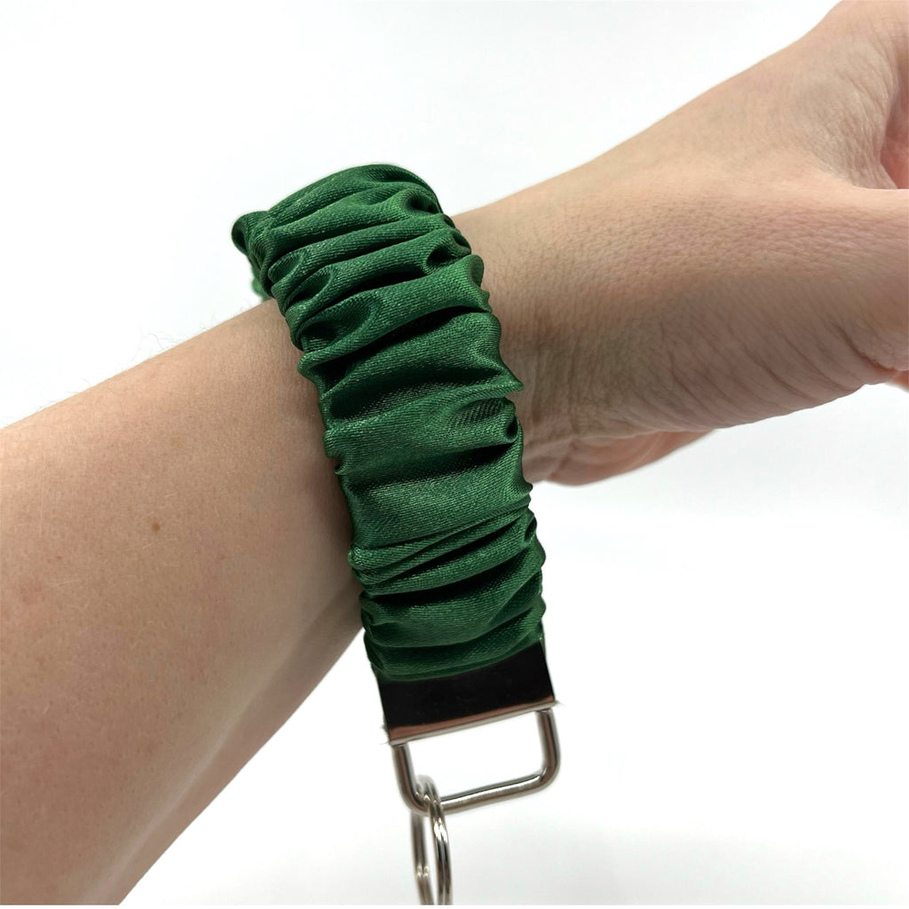 mörkgrön scrunchie nyckelring på handleden