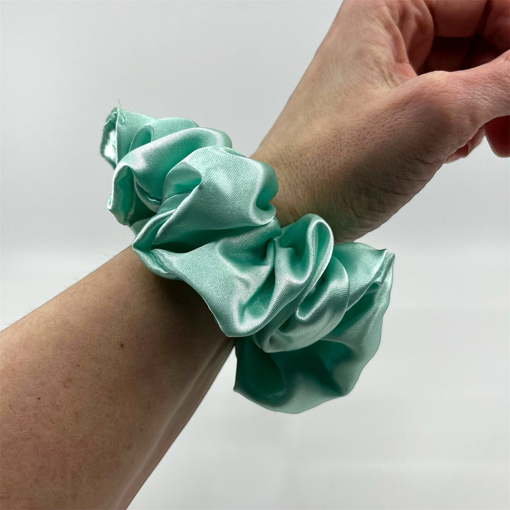 mintgrön classic satin scrunchie på handleden