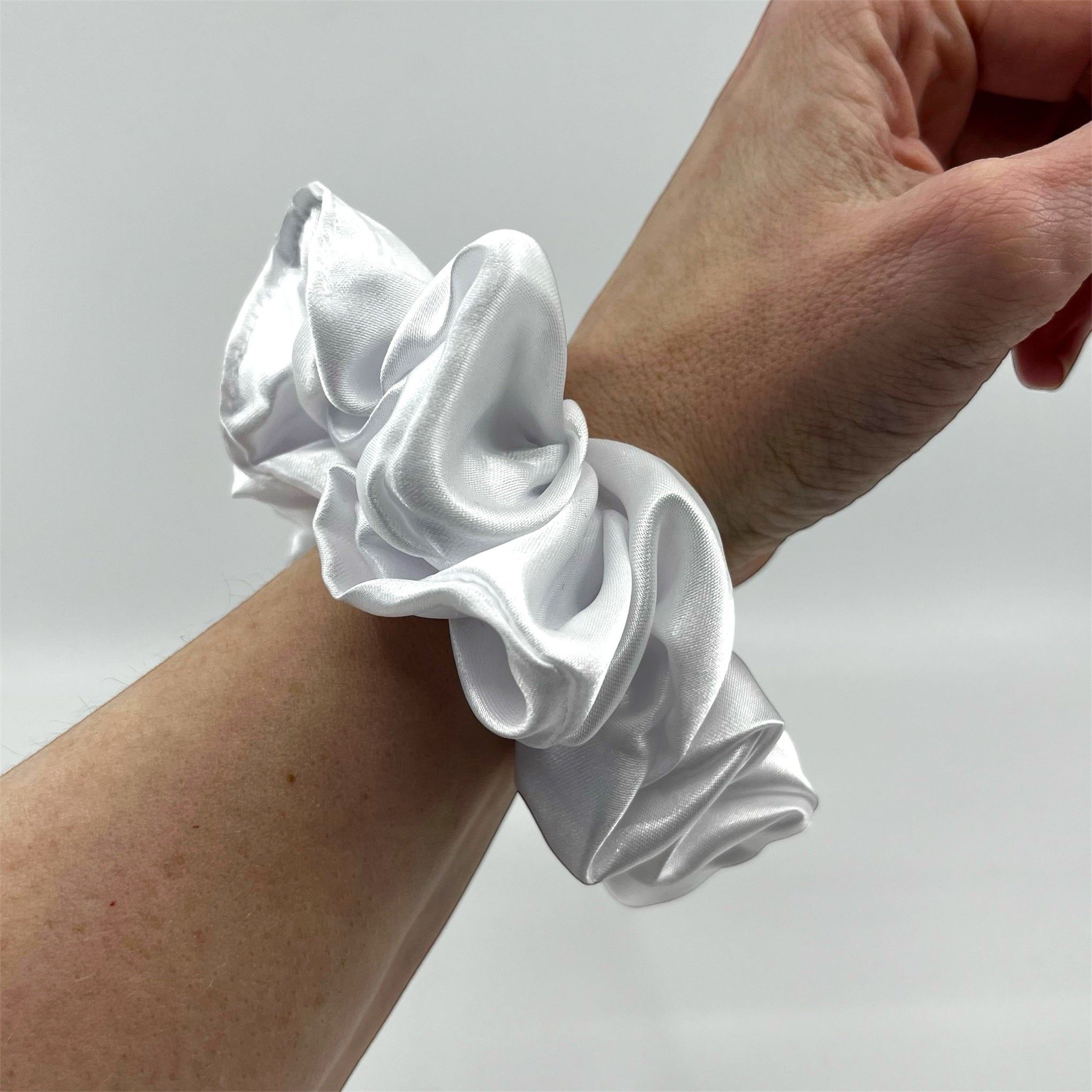 vit classic satin scrunchie på handleden