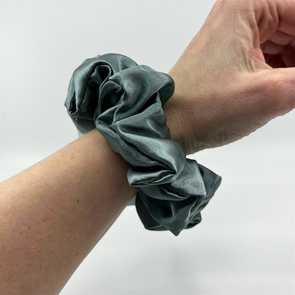 dimgrön classic scrunchie på handleden