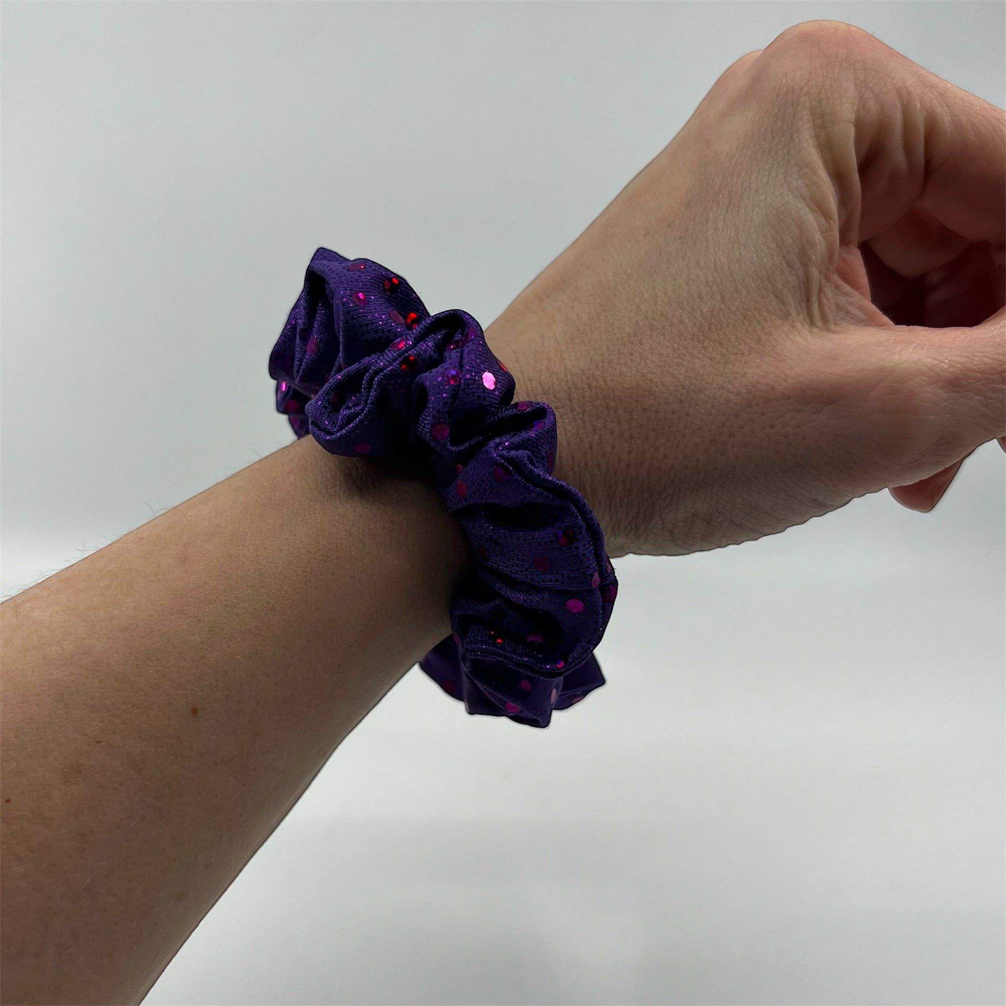 lila glitter mini scrunchie på handleden
