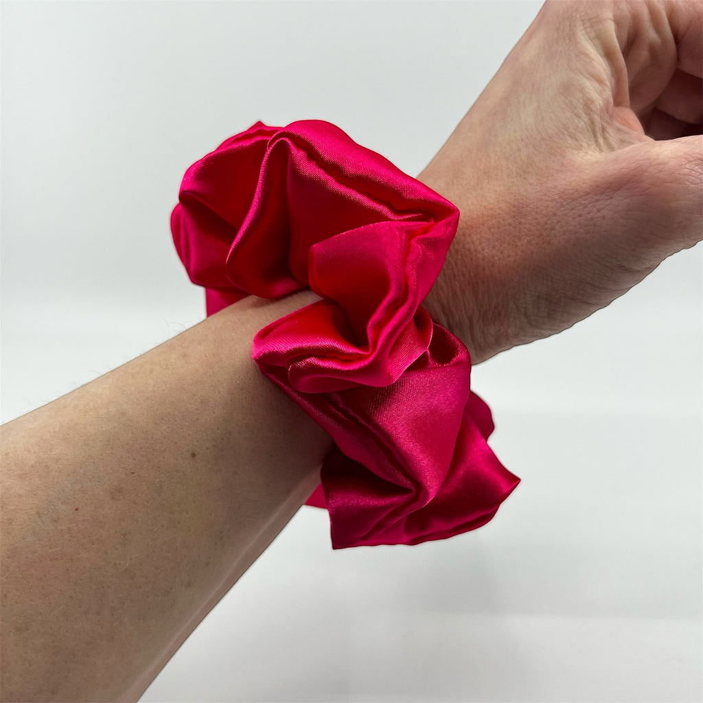 mörkrosa classic satin scrunchie på handleden