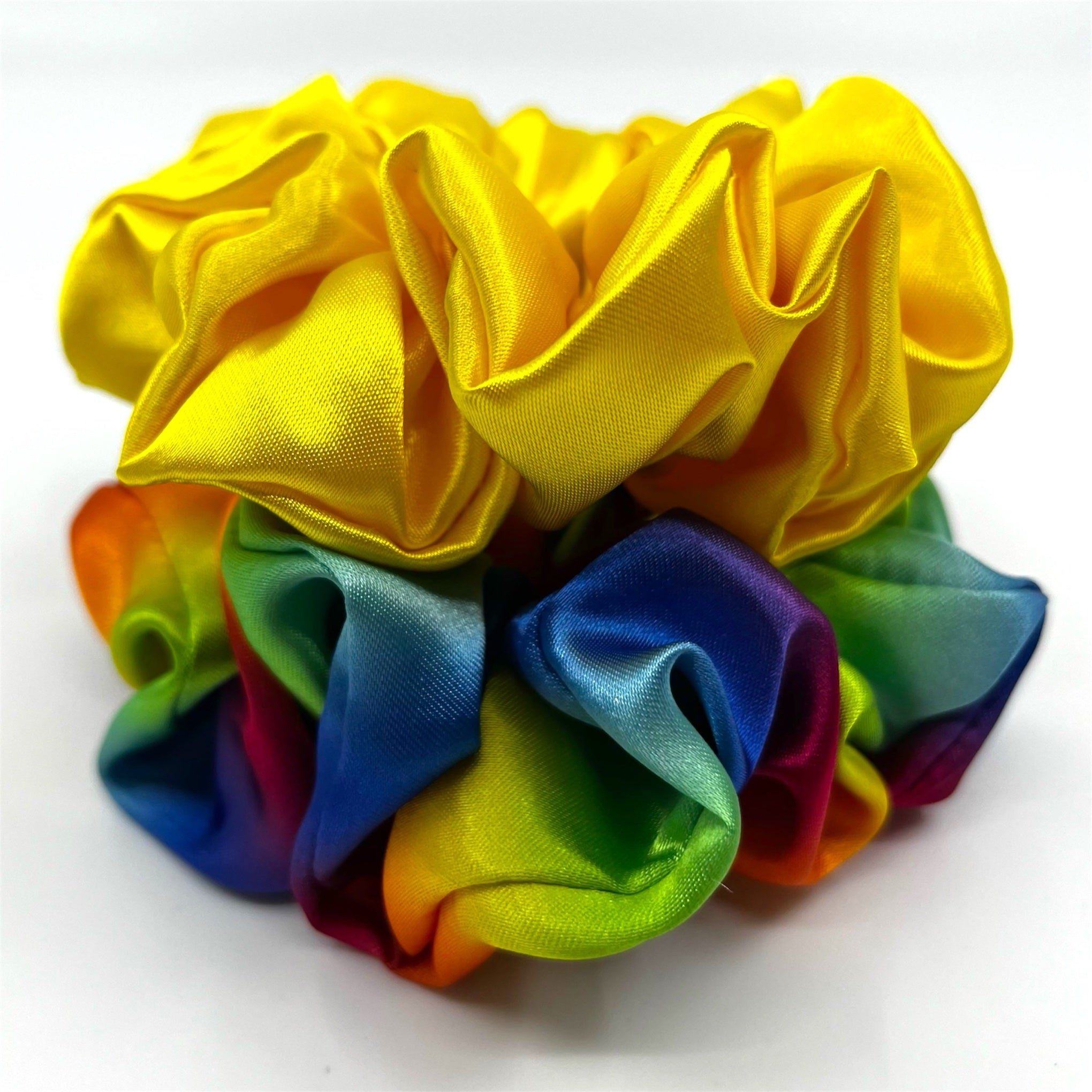 regnbåge classic satin scrunchie liggandes på torn