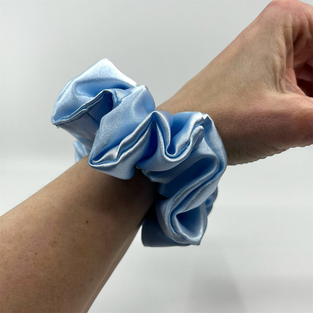 ljusblå classic satin scrunchie på handleden