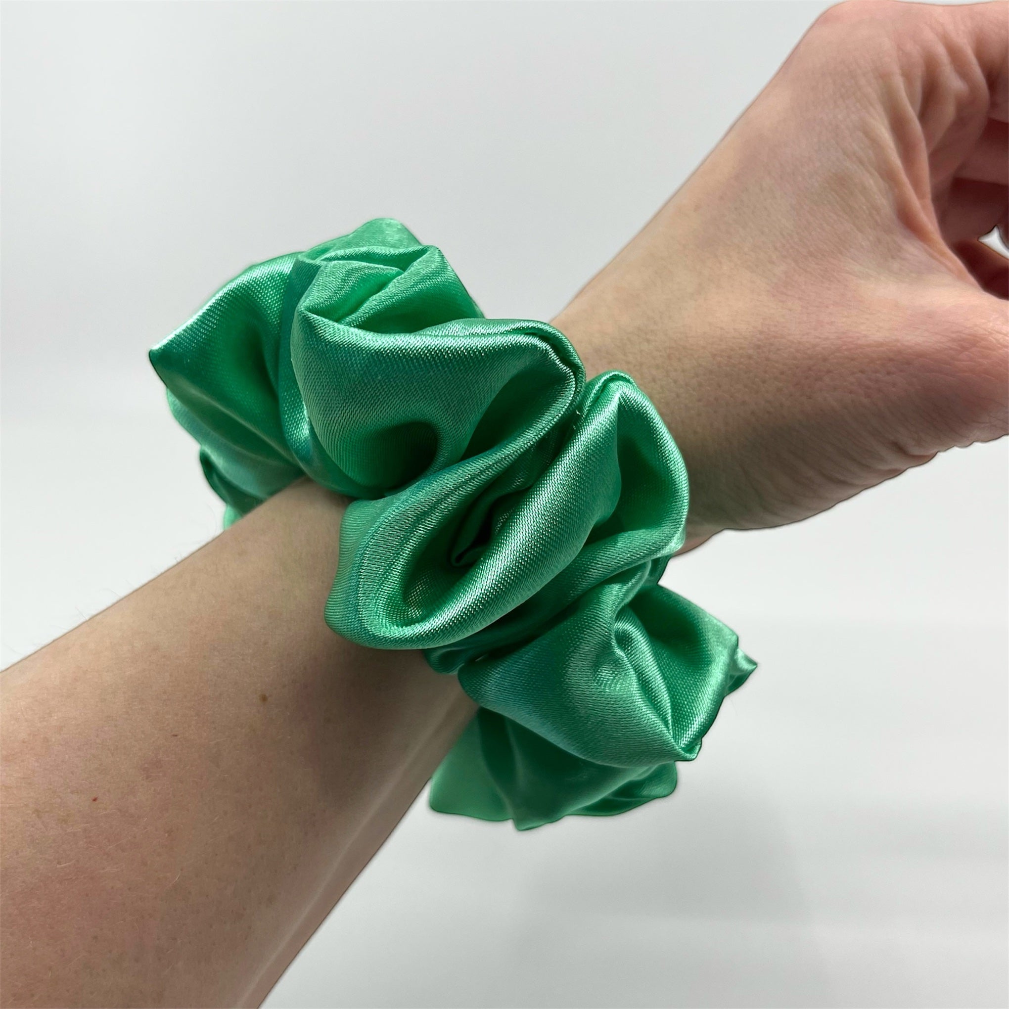 grön classic satin scrunchie på handleden