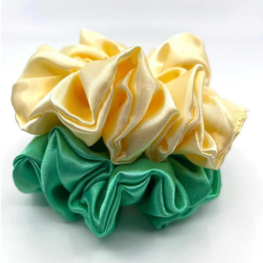 grön classic satin scrunchie liggandes på torn