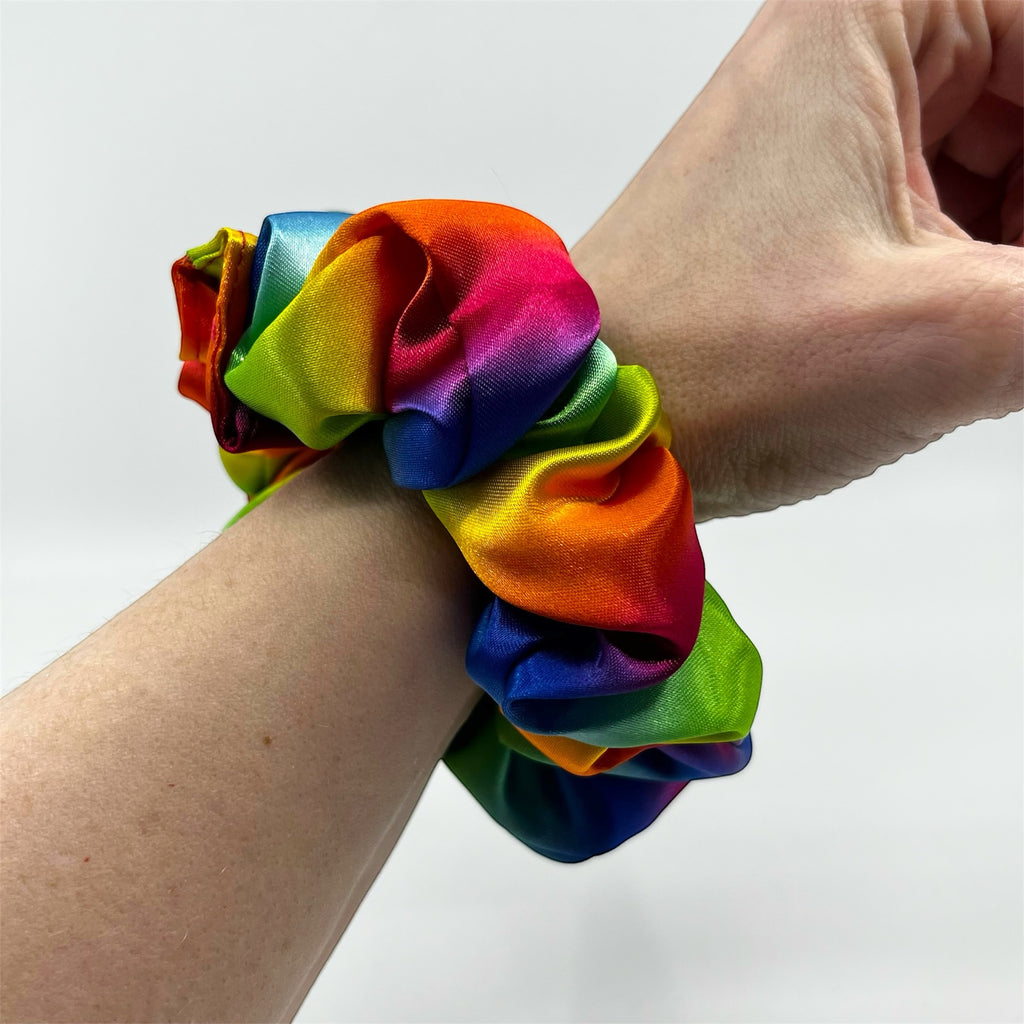 regnbåge classic satin scrunchie på handleden