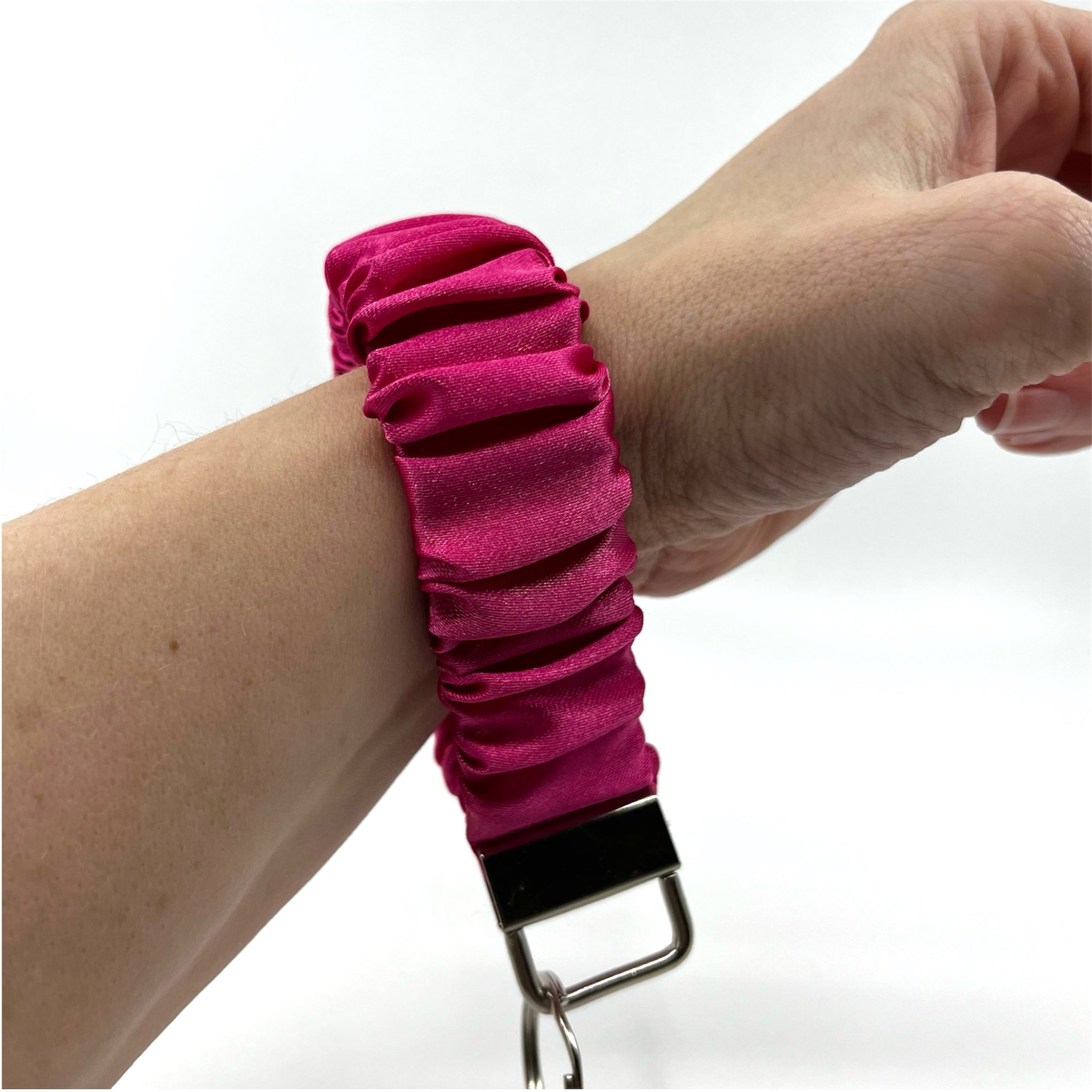 rosa scrunchie nyckelring på handleden
