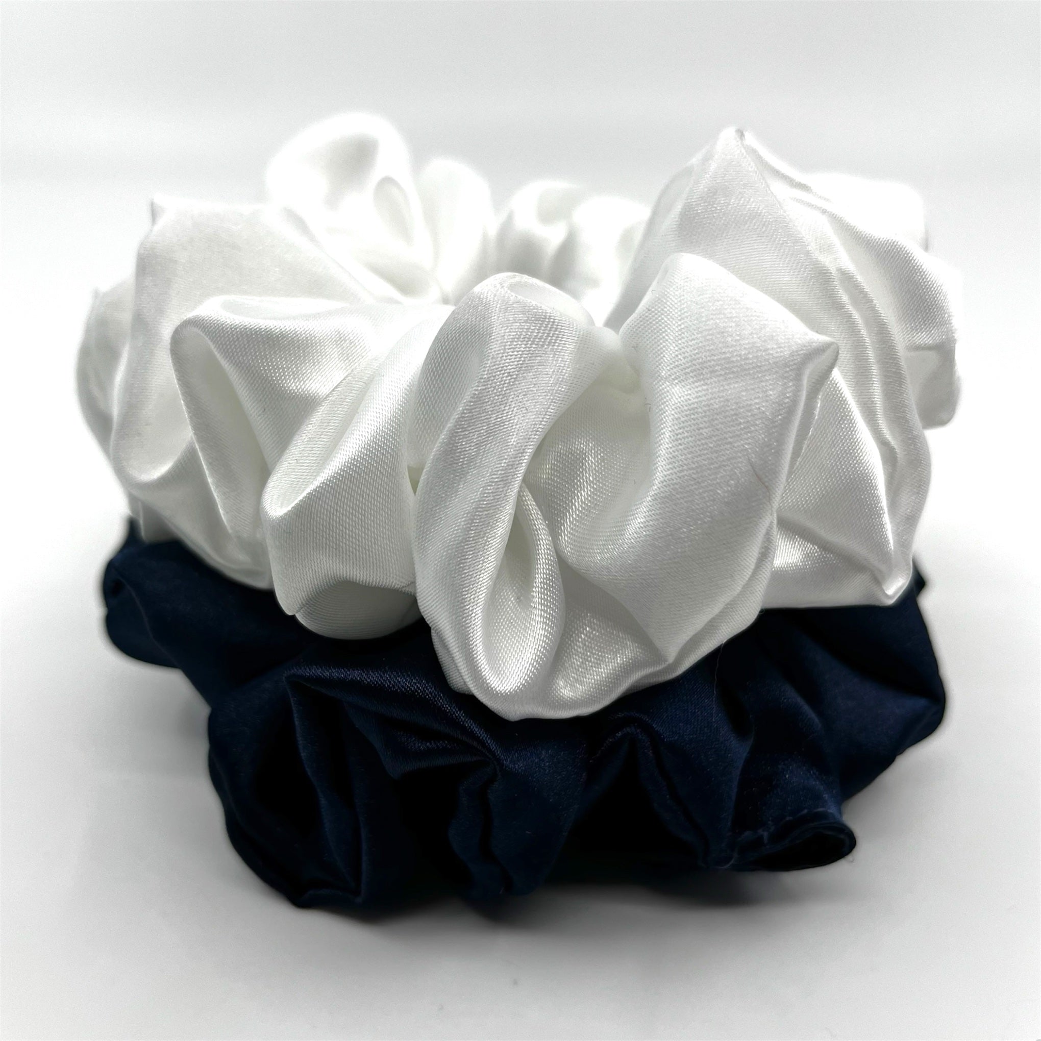 vit classic satin scrunchie liggandes på torn
