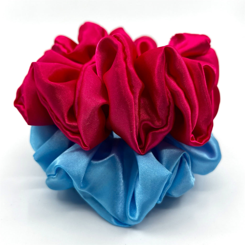 mörkrosa classic satin scrunchie liggandes på torn