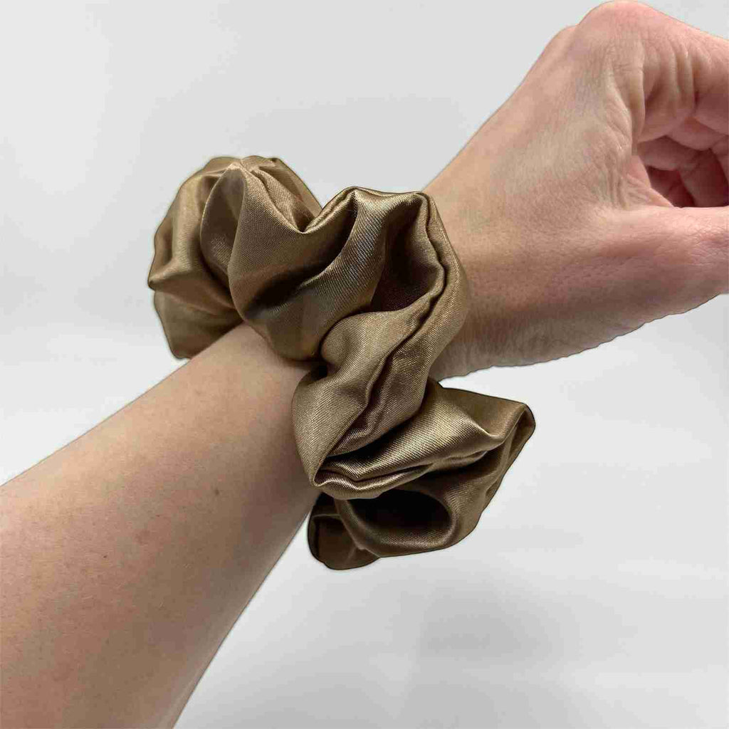 ljus koppar classic satin scrunchie på handleden