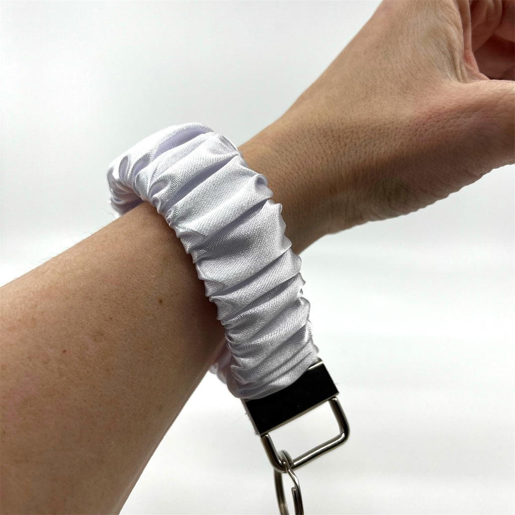 vit scrunchie nyckelring på handleden