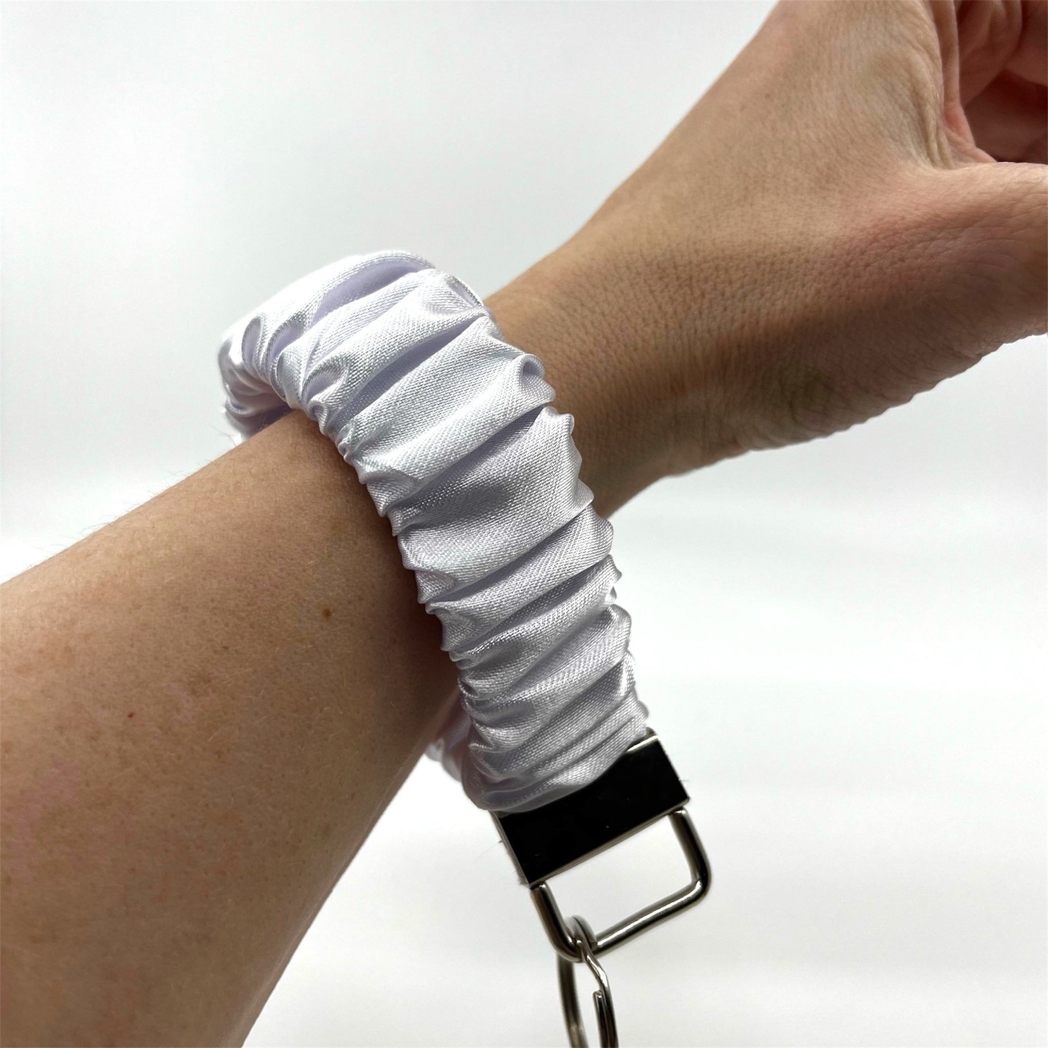 vit scrunchie nyckelring på handleden